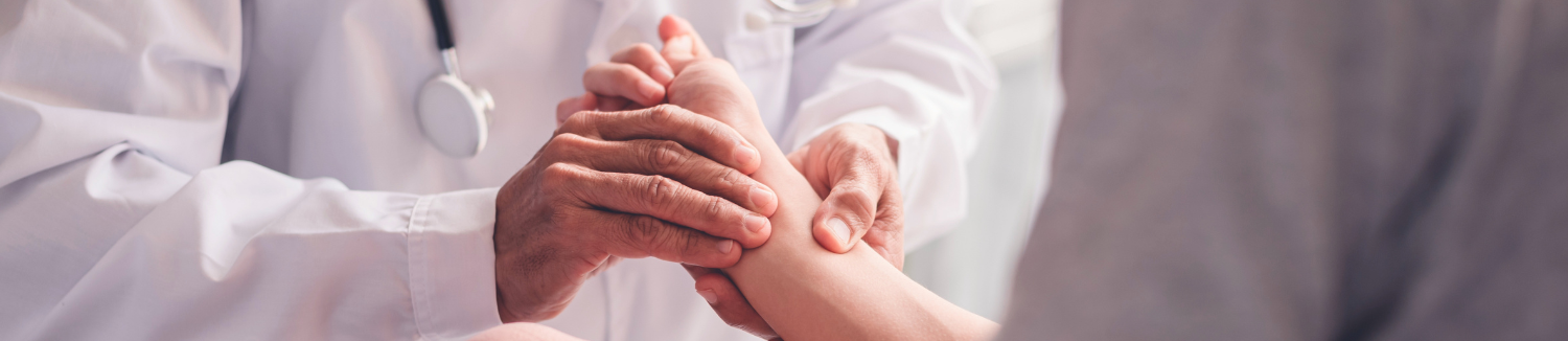 Provider examining a patient’s hand during a consultation for painful spasticity treatment.